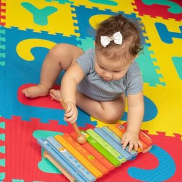 baby playing with xylophone with stick