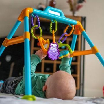 baby playing with jungle gym for tactile sense development