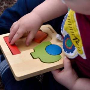 A child playing with early learning wooden puzzle